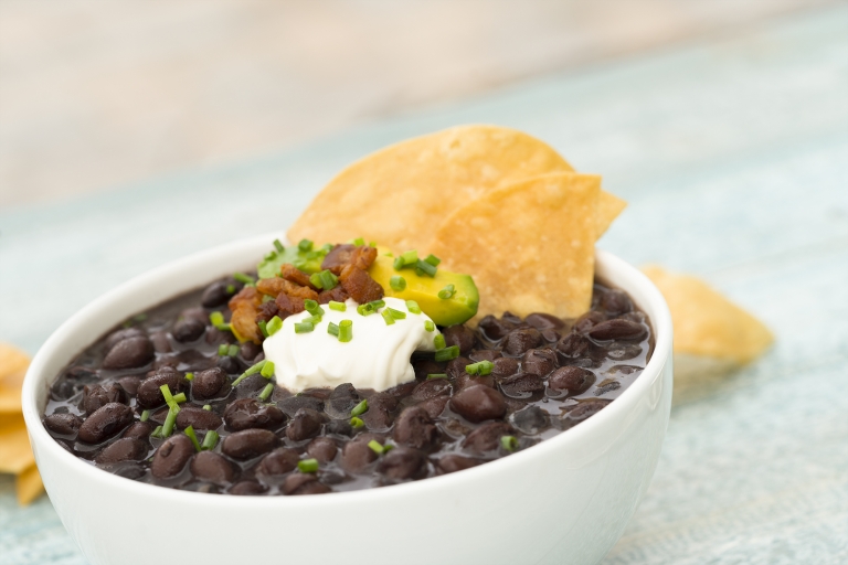 Cuban Black Beans with Bacon Garnished with Tortilla Chips, Crème Frâiche, Bacon and Chives